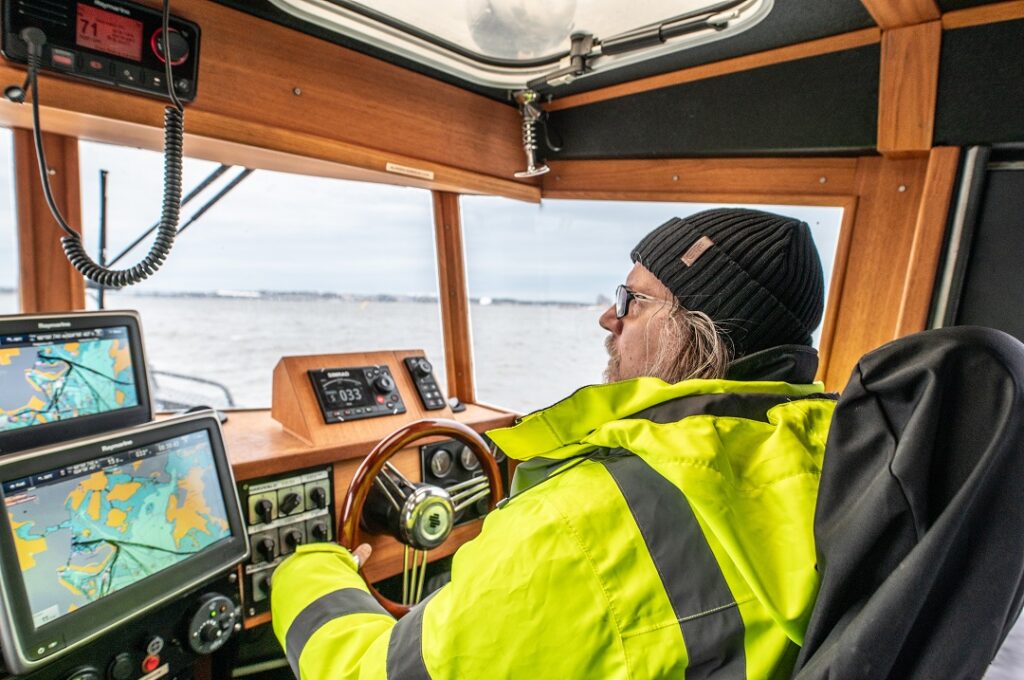 Waterway maintenance boat inspecting a sea mark